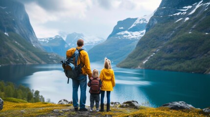 A family stands with their back and admires the view of snowy mountains and lake. A traveler traveling on vacation in the most beautiful place in the world. Winter vacation - obrazy, fototapety, plakaty