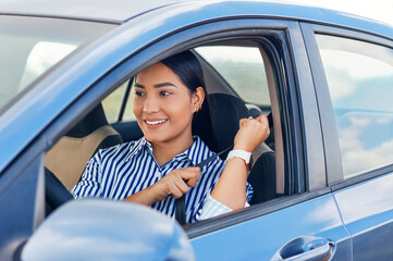 A beautiful young woman smiling while putting her safety belt in the car