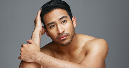 Face, cosmetics and Asian man with beauty, wellness and dermatology on a grey studio background....