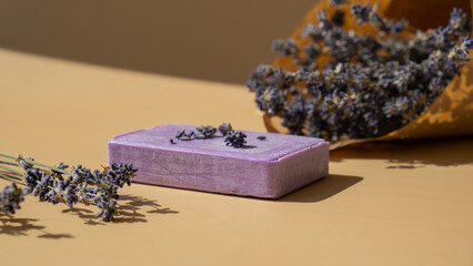 Lavender soap on beige background with copy space for your text. Advertisement template mock up. Skincare homemade natural cosmetic concept. Organic dry lavender flower
