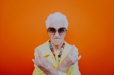 Funny grandmother portraits. Senior old woman dressing elegant for a special event. Rockstar granny on colored backgrounds - 733637600