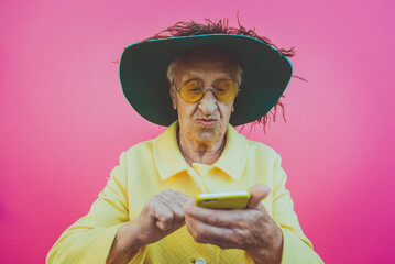 Funny grandmother portraits. Senior old woman, interacting with a smartphone. Concept about seniority - 733637608