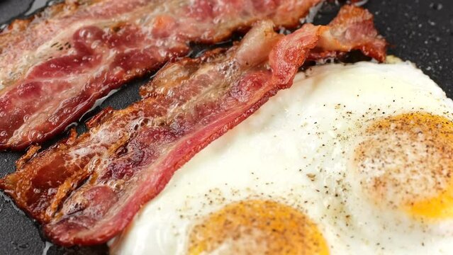 Eggs and bacon. Cooking bacon and eggs on pan, slider shot