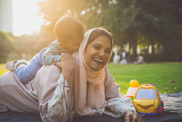 Happy lifestyle moments. Mom and his baby enjoying time in Dubai outdoor in a park.