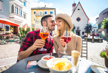 Happy couple taking an aperitif in a cafè.