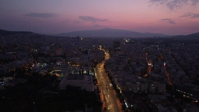 This footage is made with a drone during the sunrise when the sky had pink color with a panoramic view of the Athens