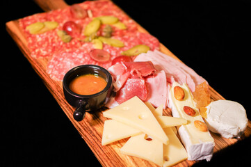 charcuterie meat and cheese tray with cold cut, pickled cucumber, olive and nuts antipasto board...