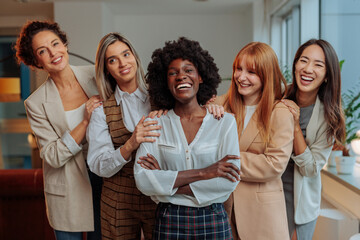 Team of happy businesswomen posing together and laughing