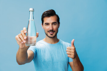 Man drink water portrait happy attractive bottle blue smile studio t-shirt lifestyle healthy sport