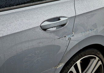 scratched side of car. small scratches on paint can be repaired by puttying, sanding with 2000-grit sandpaper, followed by spraying with a color filler and transparent painting. car paint shop, store