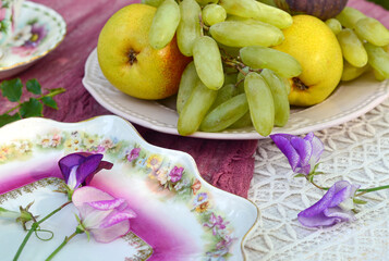 Green grapes and pears on the table in a plate, vintage style