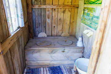 Rustic old-fashioned outhouse for two