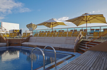 Deck chairs or sun loungers on balcony or terrace or patio pool deck of luxury modern cruise ship cruiseship liner with amazing ocean view	
