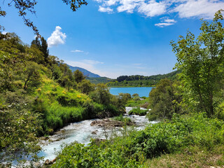 Fototapeta na wymiar Mountain river filling a turquoise lake with crystal water