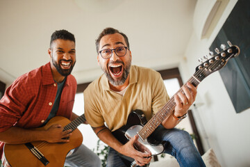 Best friends, musician jamming together. Playing music on guitar together, having fun. Concept of...