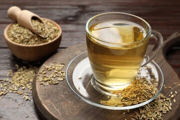 Aromatic fennel tea and seeds on wooden table, closeup. Space for text