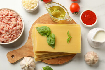 Ingredients for lasagna on white marble table, flat lay