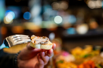 man's hands spreading liver pate on toast bread