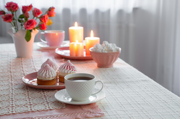 cup of coffee with dessert and roses on table