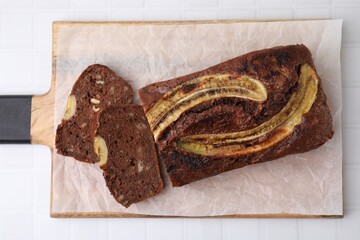 Delicious banana bread on white tiled table, top view