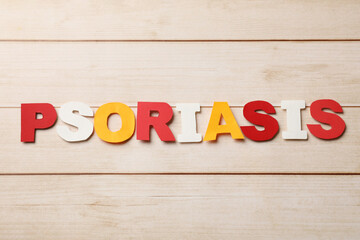 Word Psoriasis made of paper letters on wooden table, top view