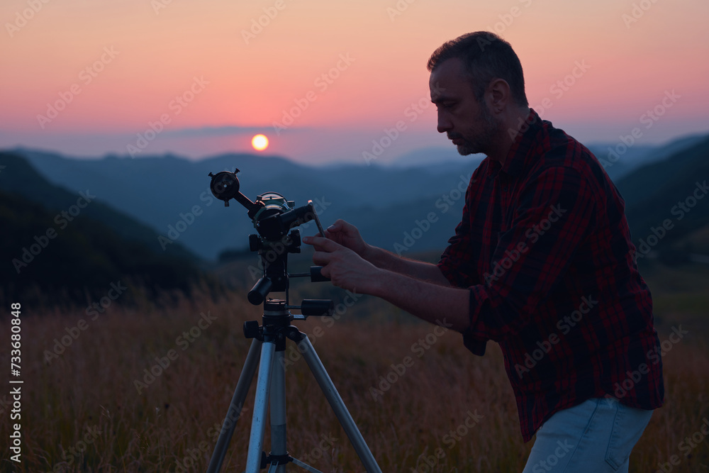 Canvas Prints astronomer looking at the sun with a telescope and using a cellphone.