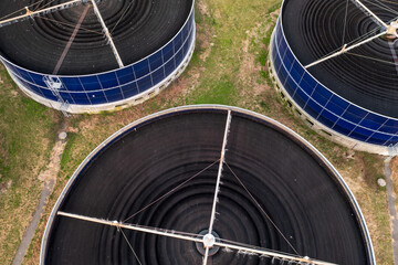 Aerial top view of massive round water tank for water filtration in water treatment plant.
