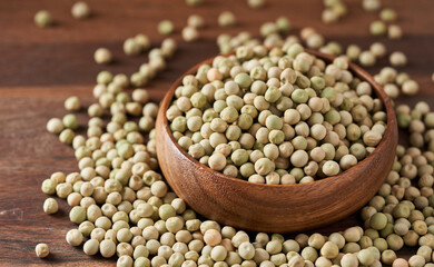 dry green pea matar in wooden bowl on wood table food background closeup
