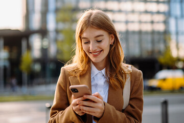 Professional Businessperson with Layered Hair and Formal Attire Smiling while Holding a Mobile Phone in Hand