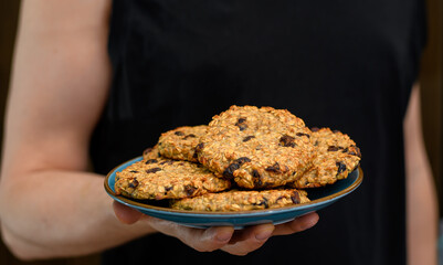 Ciastka owsiane z suszonymi owocami na talerzu trzymane w ręce  © Paweł Kacperek