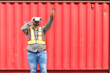 shipyard worker is using VR or Virtual Reality goggles to inspect the imported cargo. 