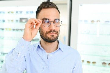 Obraz premium Man choosing glasses in eyewear store