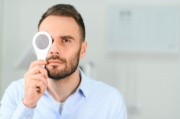 Test of sight. Man is checking his vision indoors in the clinic