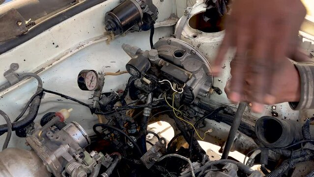 Swat, Pakistan - 04 December 2023: close up detail of an old automobile engine by take off a cover from crankcase to check and repair at garage.