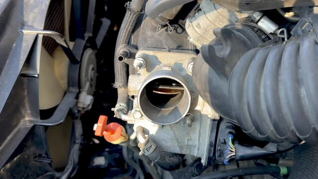 Checking and examining of a car Throttle Body for repairing and cleaning work.