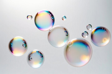 Iridescent soap bubbles floating on white background