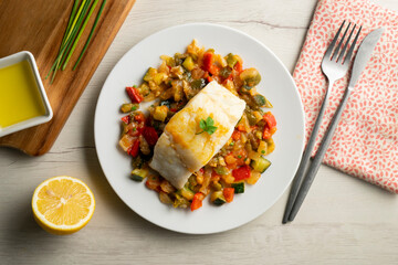 Cod tapa cooked with vegetables in samfaina. Traditional recipe of Spanish gastronomy.