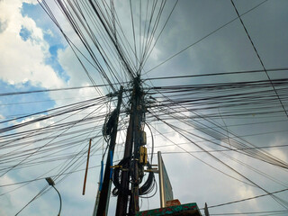 Messy power cables on poles in Indonesia