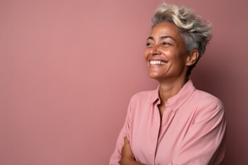 Portrait of a happy senior woman with short hair on pink background
