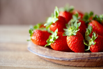 Strawberries on a wooden plate. Copy space. Strawberries on a wooden table