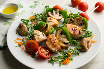 Organic chicken skewers with mushrooms and salad.