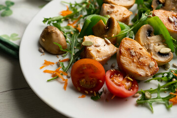Organic chicken skewers with mushrooms and salad.