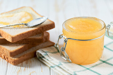 Delicious ginger jam on table close-up. Bread and ginger jam on wooden table.