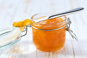 Orange jam on a white wooden table, selective focus.