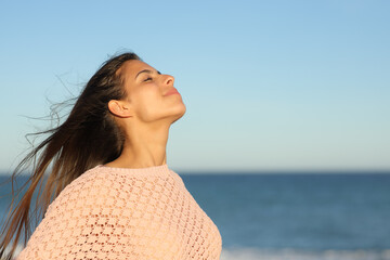 Woman at sunset breathing on the beach