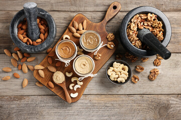 Making nut butters from different nuts. Fat lay composition on wooden table