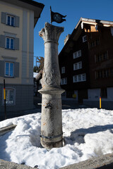 Schneebedeckter Brunnen in Hospental, Kanton Uri, Schweiz - obrazy, fototapety, plakaty
