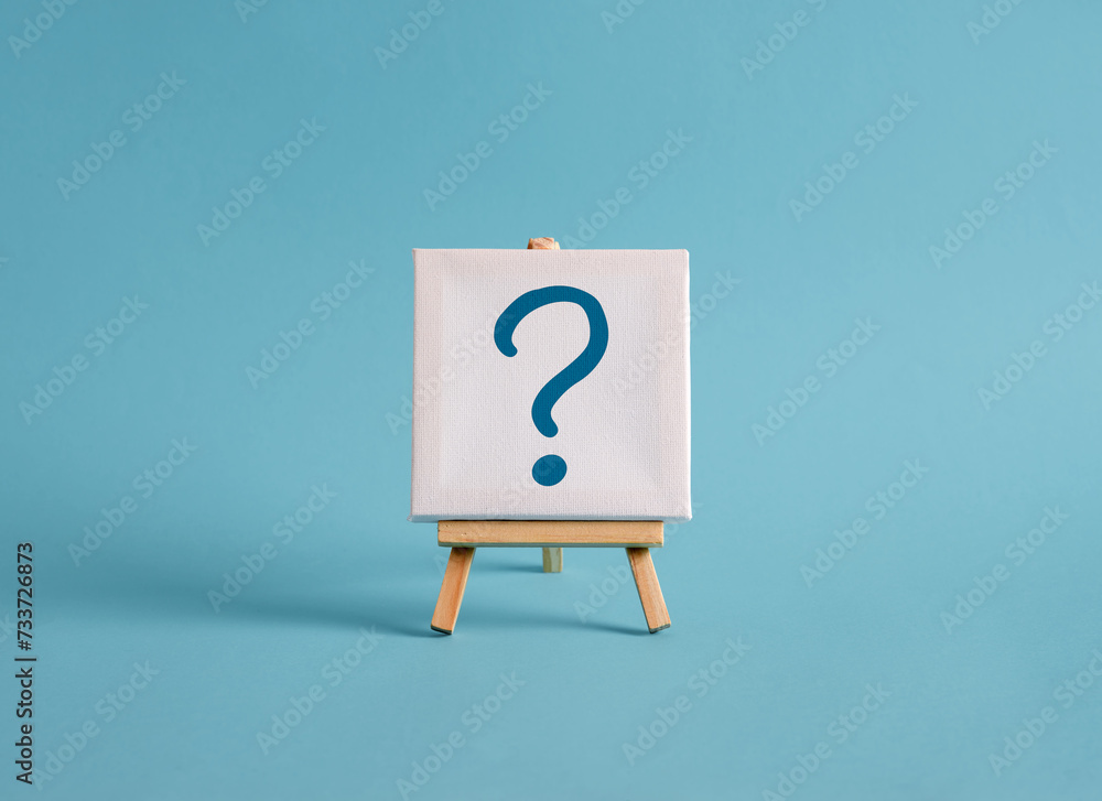 Poster a canvas with question mark symbol on an easel with blue background.