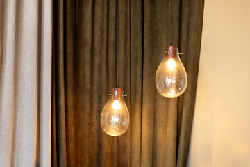 Modern transparent glass lamps in the shape of balls on thin laces. Vintage light bulbs hanging...