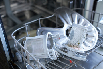 Dishwasher filters in the bottom of the dishwasher. The concept of appliance repair, service and maintenance.